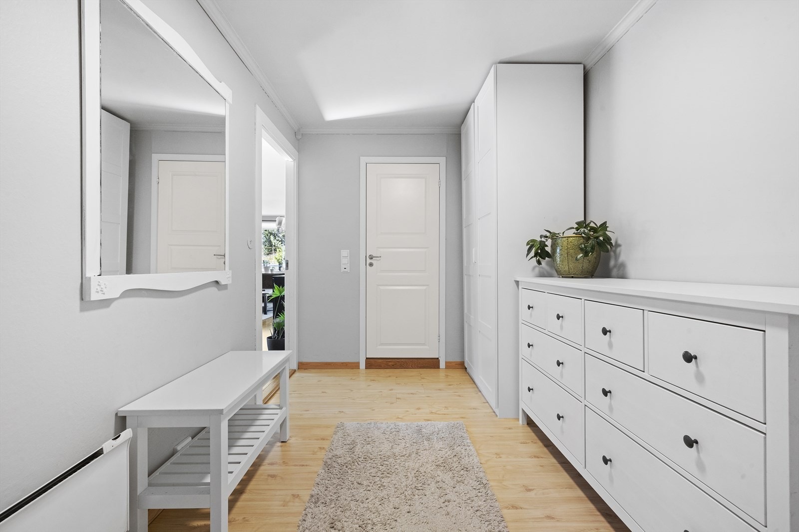 Fra felles inngangsparti stiger man inn i leilighetens romslig entrè. Her er det god plass til garderobeskap og øvrig møblement for oppvaring av yttertøy og sko Galleribilde