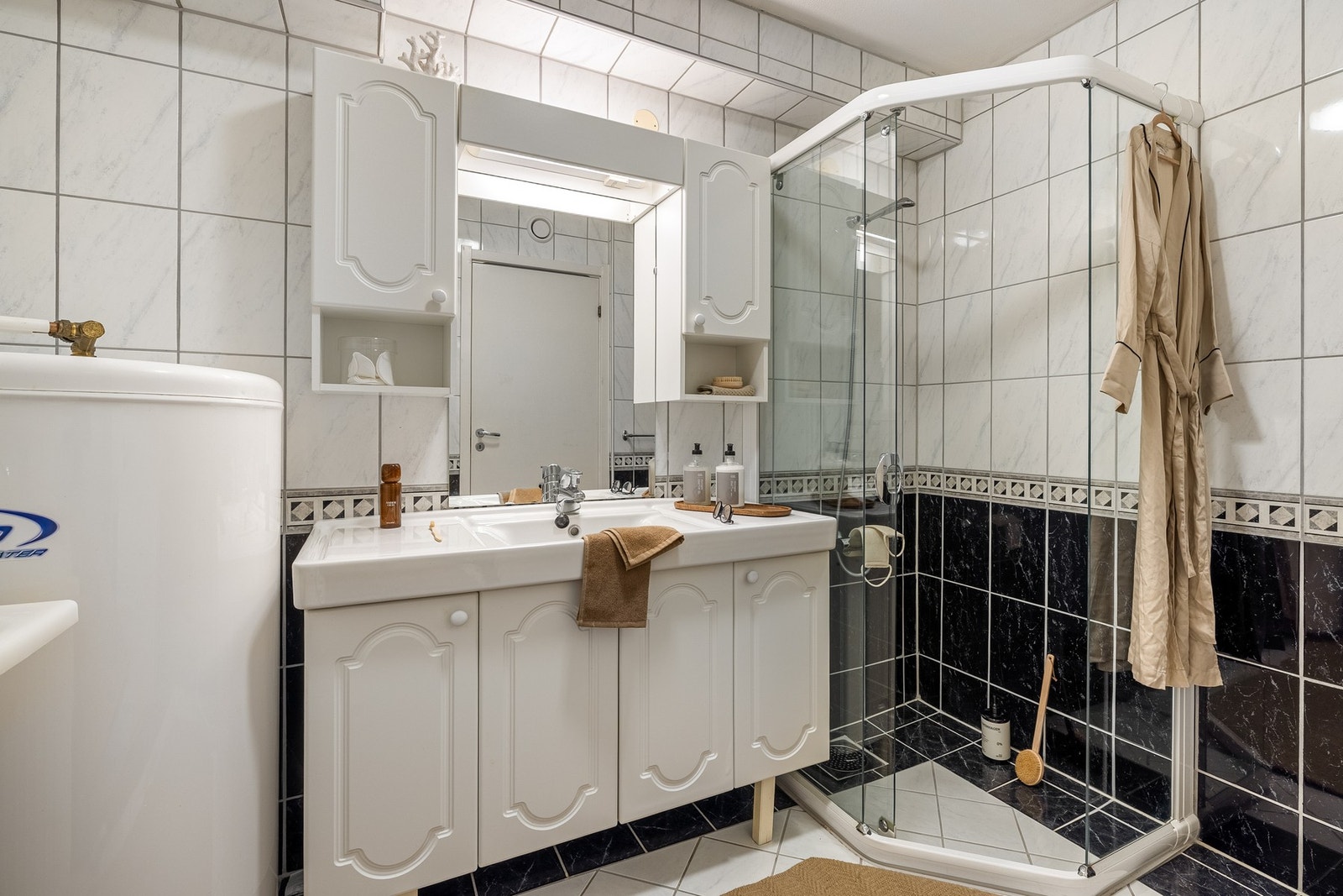 Badet er innredet med dusjhjørne, baderomsinnredning, skyllekar, varmtvannstank på 198 liter fra år 2000 og opplegg for vaskemaskin. Galleribilde