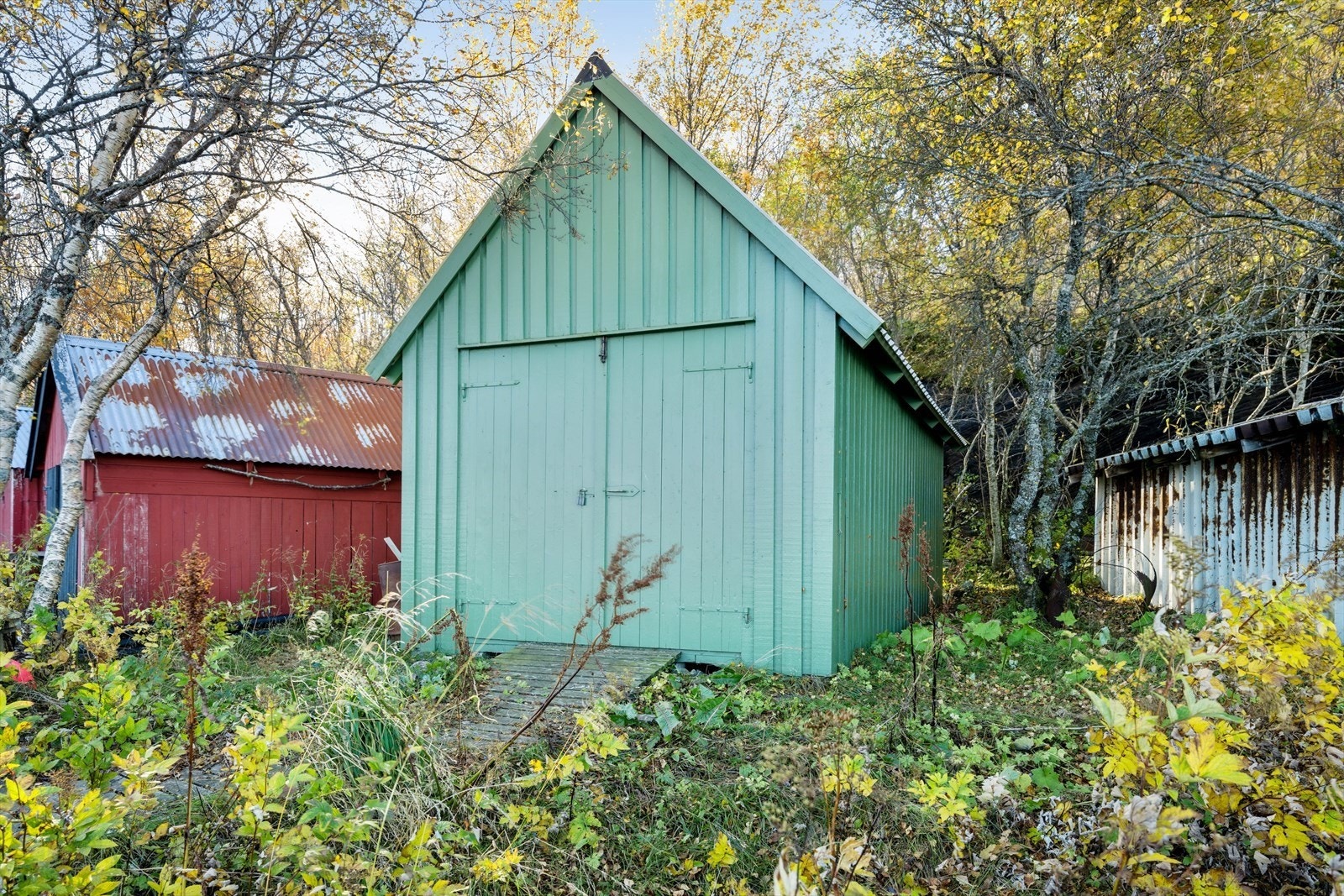Naust i gruppe. Båtstø med skinnegang og dører mot sjøen for adkomst med båt. Galleribilde