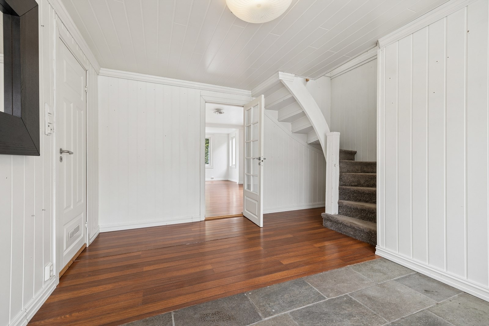 Innbydende entré med skiferfliser på gulvet og trapp opp til andre etasje. Galleribilde