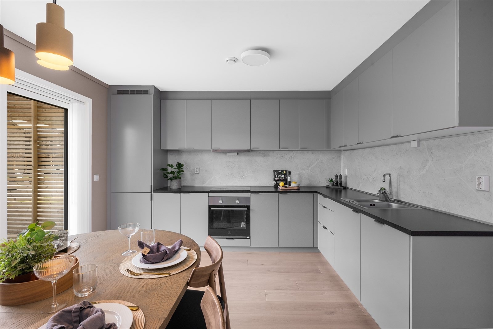 Tidløst og delikat kjøkken med grå, slette fronter og laminert benkeplate. Galleribilde