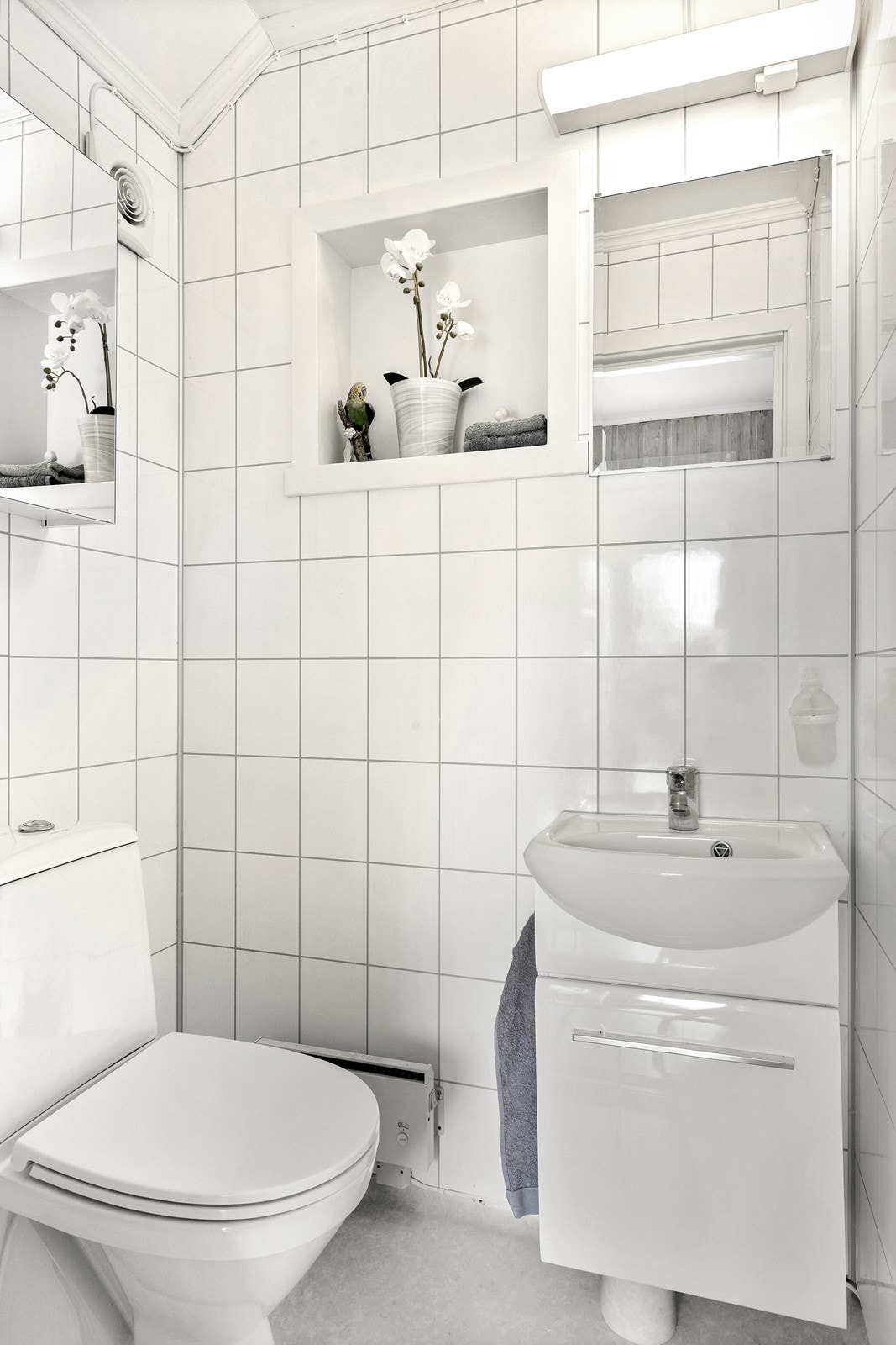 Separat toalettrom i første etasje, utstyrt med gulvmontert wc og moderne, mindre servantinnredning med speil over. Galleribilde