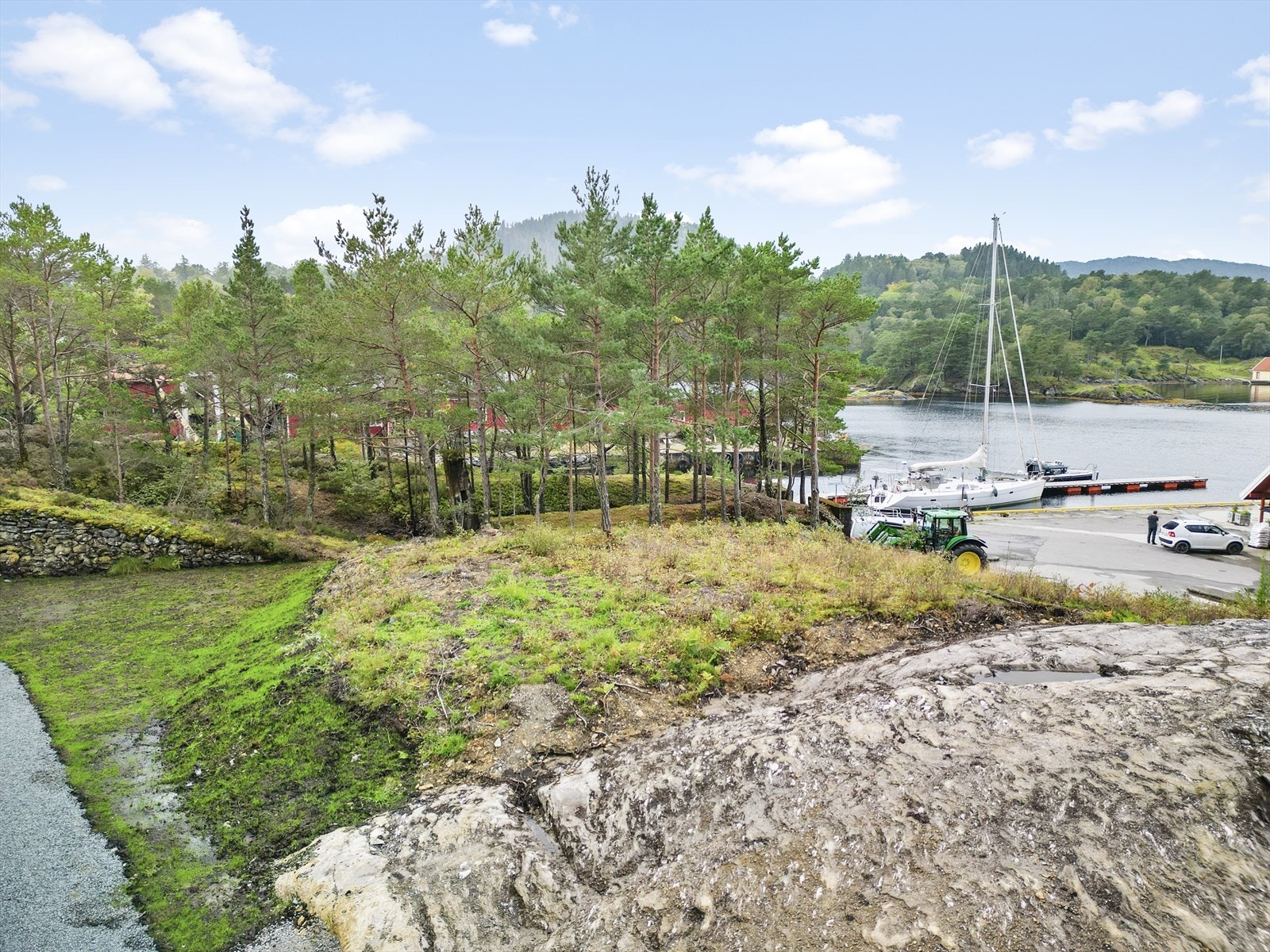 Naturtomt med svaberg og furutre rammar inn eigedomen. Galleribilde