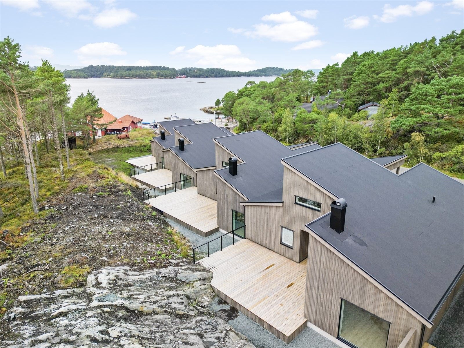 Bustadane ligg på rekkje og rad, med sjøen like ved Galleribilde