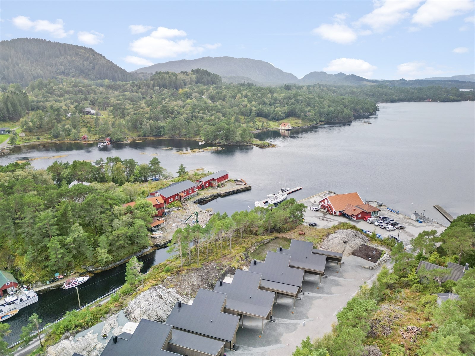 Eit oversiktsbilete som viser den unike plasseringa mellom skog og fjord. Galleribilde