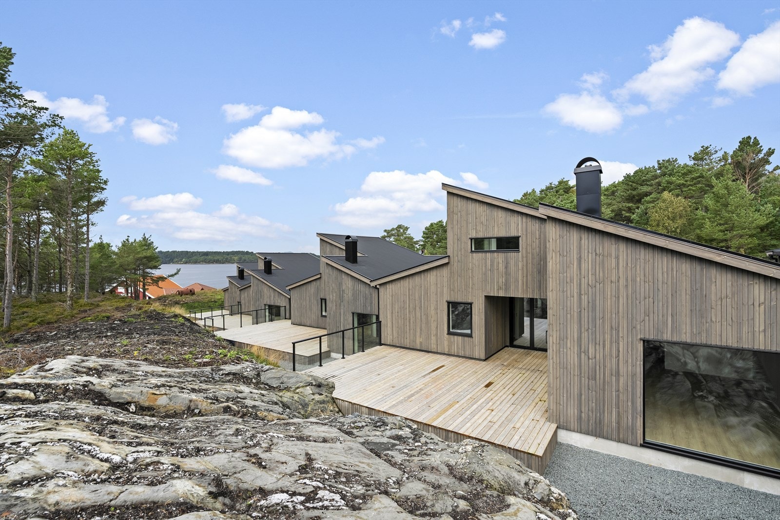 Bustaden ligg fint til i terrenget, omkransa av furuskog og svaberg. Galleribilde