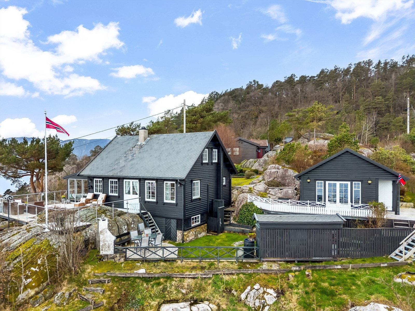 Eiendommen ligger skjermet til i terrenget med anneks og flere uteplasser rundt boligen. Galleribilde