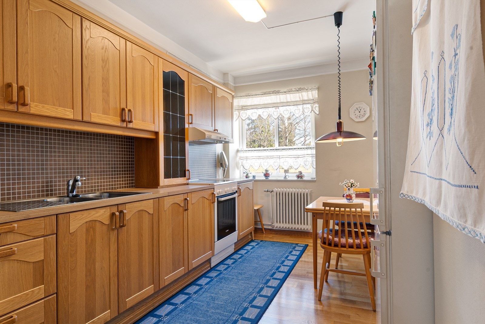 Heltre kjøkkenfronter med et vitrineskap med blyglass. Galleribilde