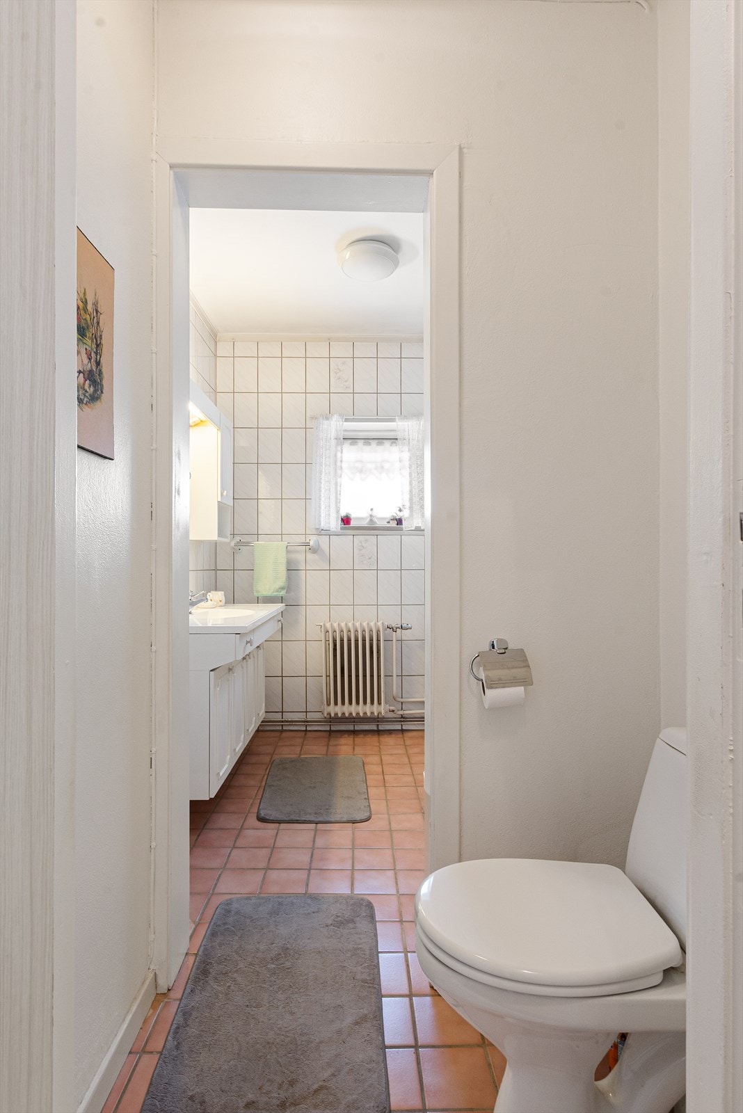 Badet er delt i 2 med toalett ytterst og dusj, servant og opplegg for vaskemaskin innerst. Galleribilde