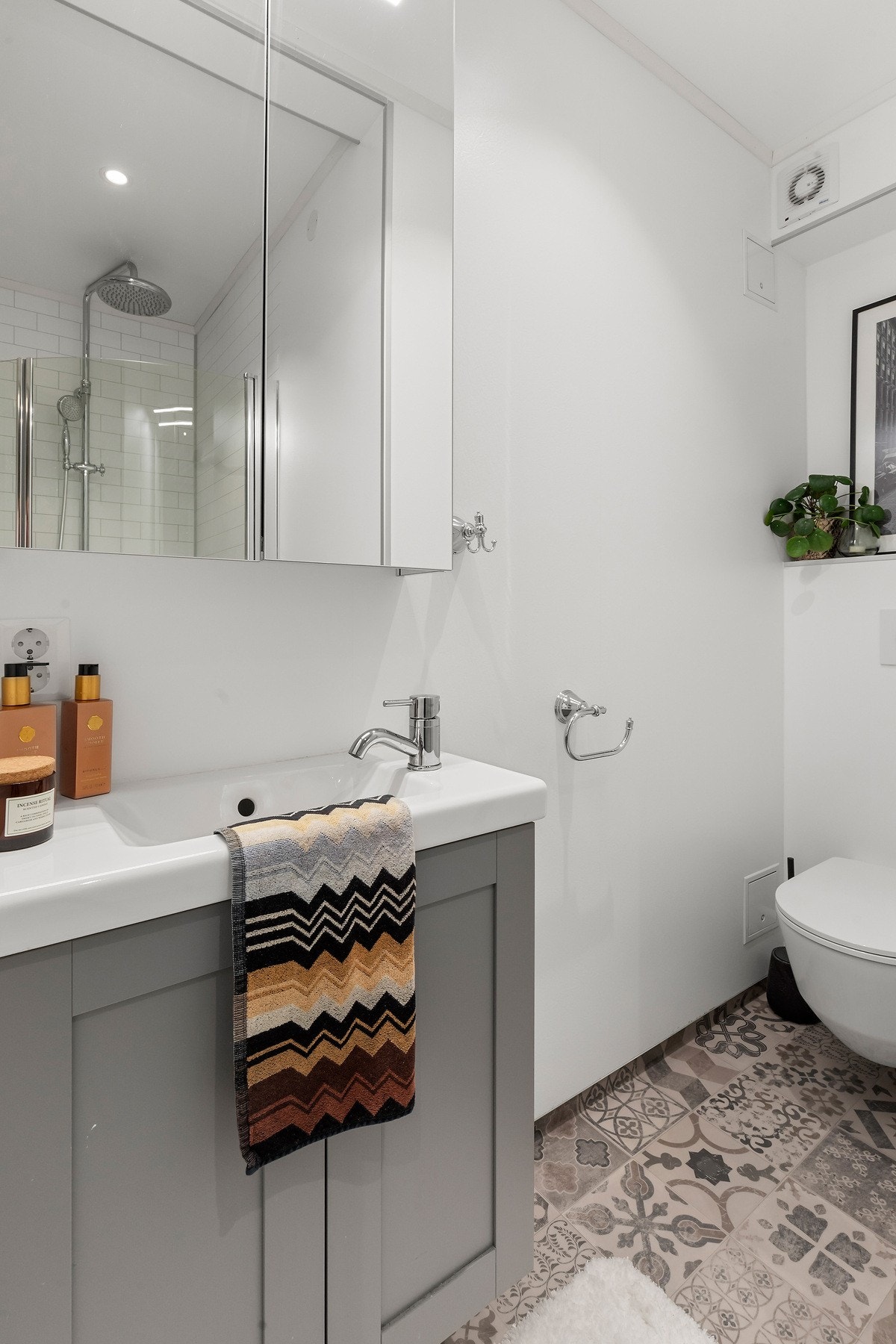 Badet er innredet med vegghengt toalett, baderomsinnredning, opplegg for vaskemaskin og dusj. Galleribilde