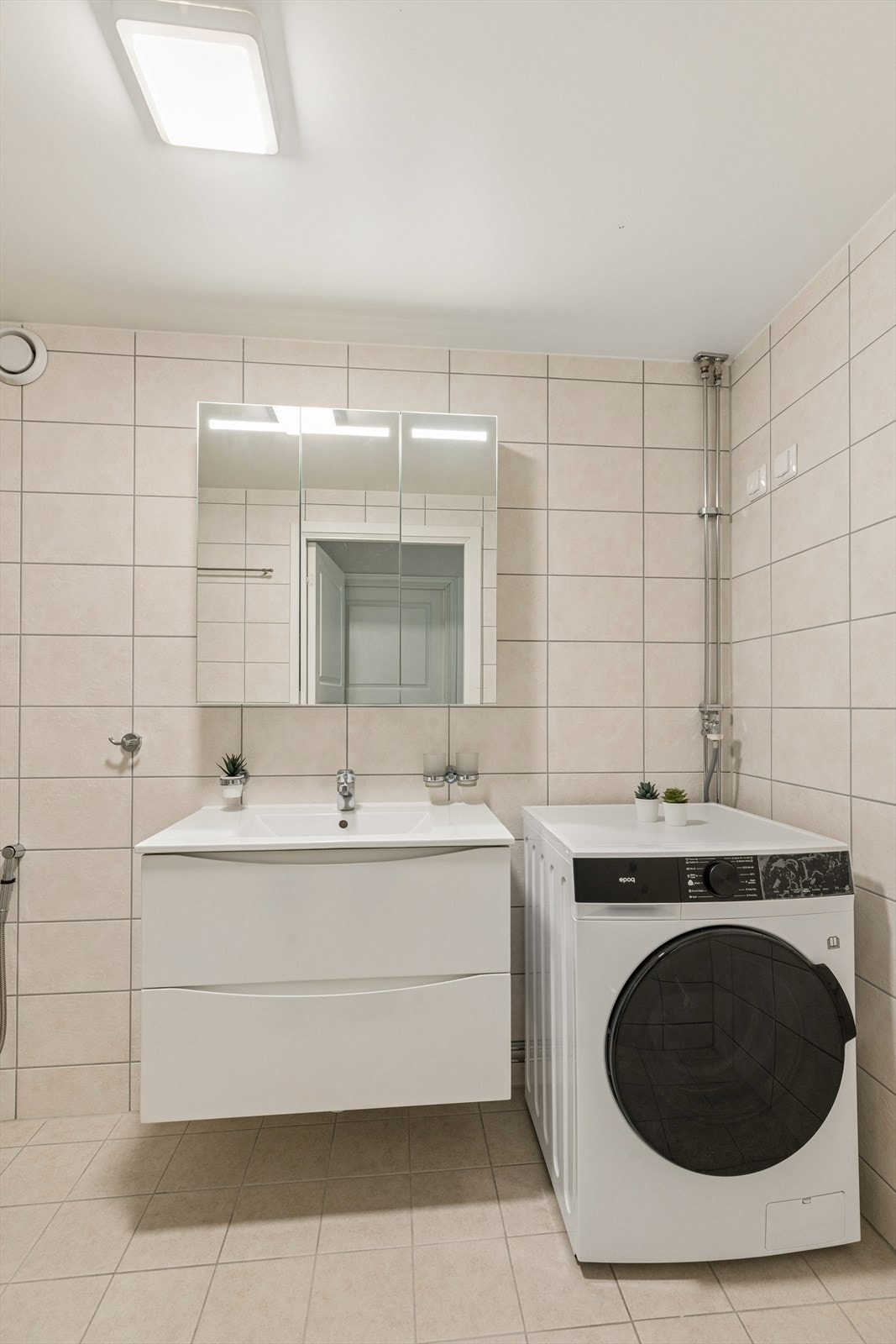 Badet fra 2023 har innredning med nedfelt servant, speilskap og opplegg for vaskemaskin. Galleribilde