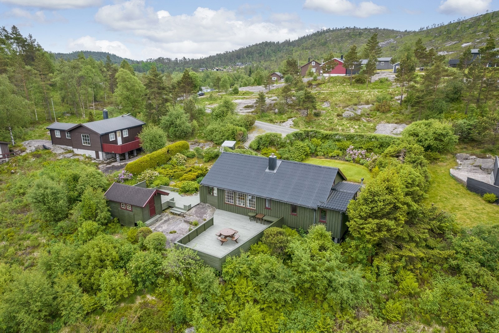 Sommerbilde fra tidligere salg. Trær er felt og området er åpnet opp foran hytta. Galleribilde