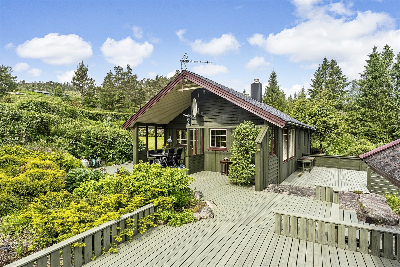 Sommerbilde fra tidligere salg. Trær er felt og området er åpnet opp foran hytta. Galleribilde