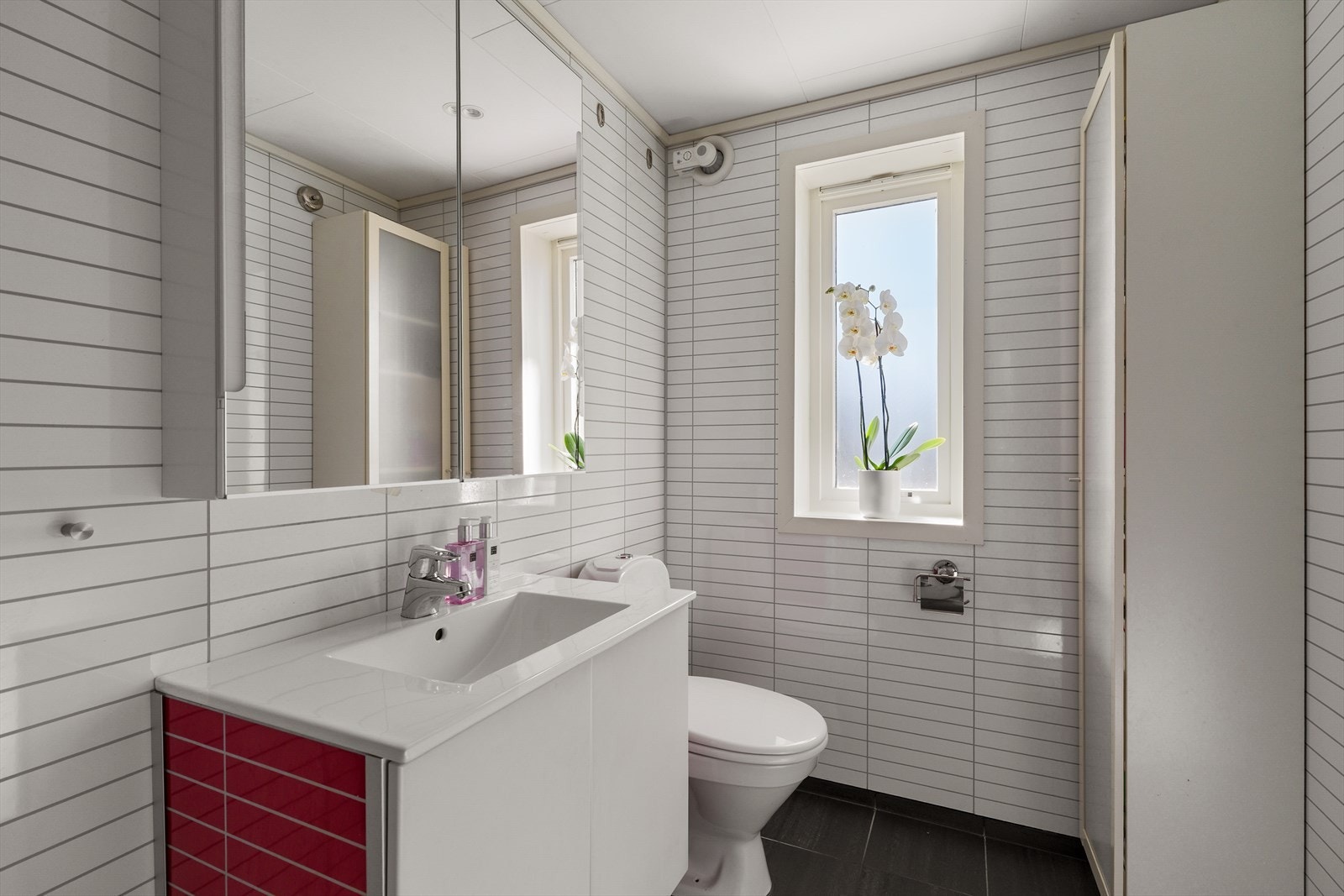 Badet har baderomsplater på veggene og takess i taket. Det er flis på gulvet, samt varmekabler for ekstra komfort. Galleribilde