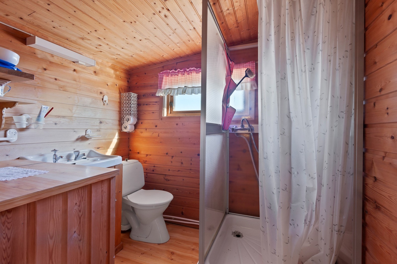 Badet har enkel innredning med servant, dusjkabinett og toalett. Badet er bygget som enkel hyttestandard uten sluk i gulvet. Galleribilde