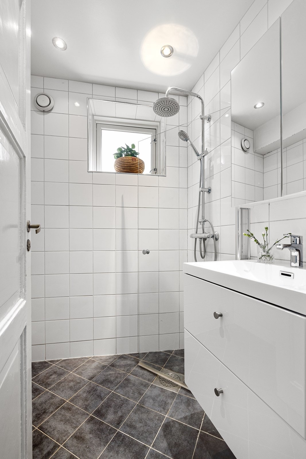 Flislagt gulv med gulvvarme. Badet har dusjplass med dusjvegger samt servant med ettgreps blandebatteri i innredning. Galleribilde