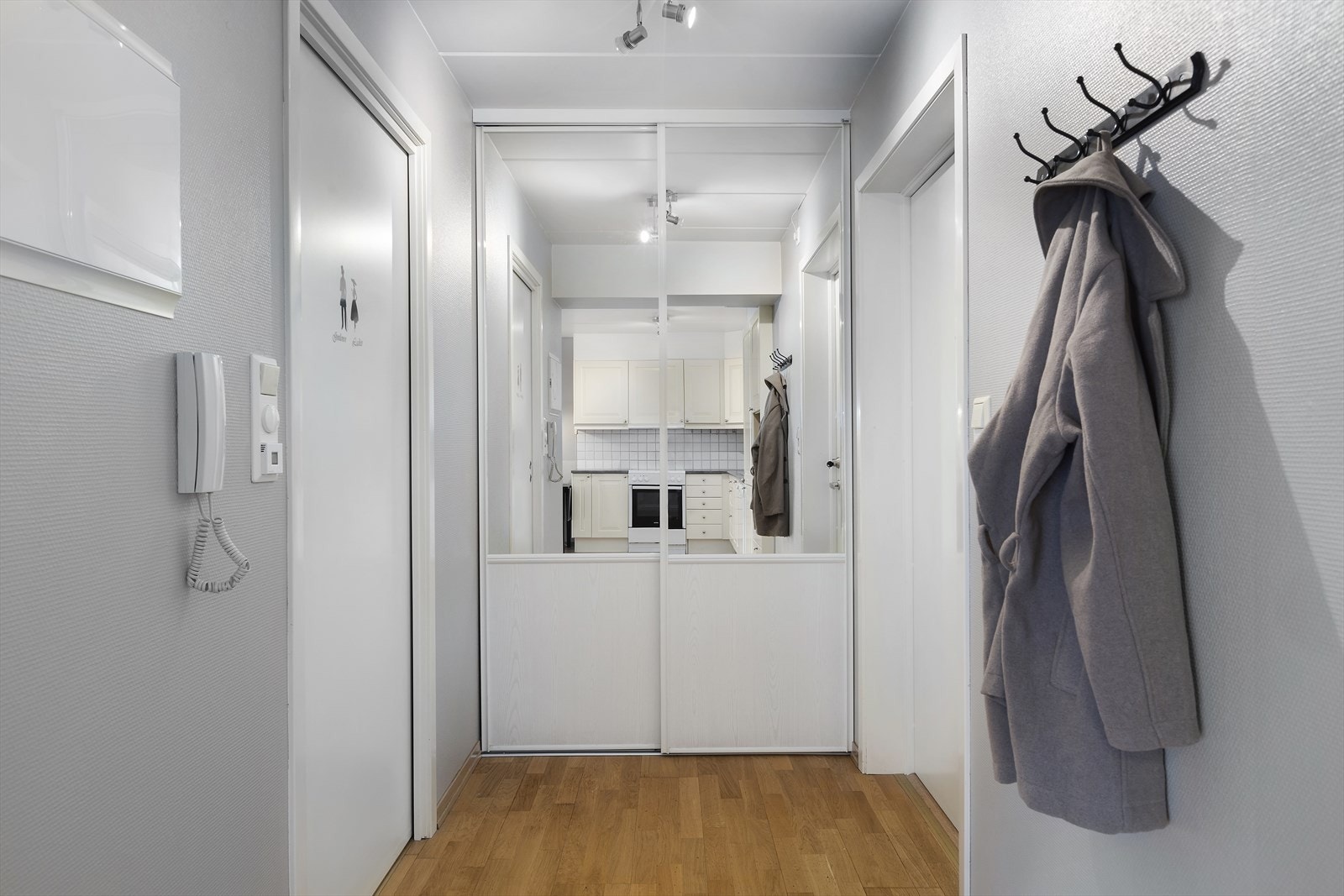 Lys entré med garderobeskap med skyvedører i speil. Galleribilde