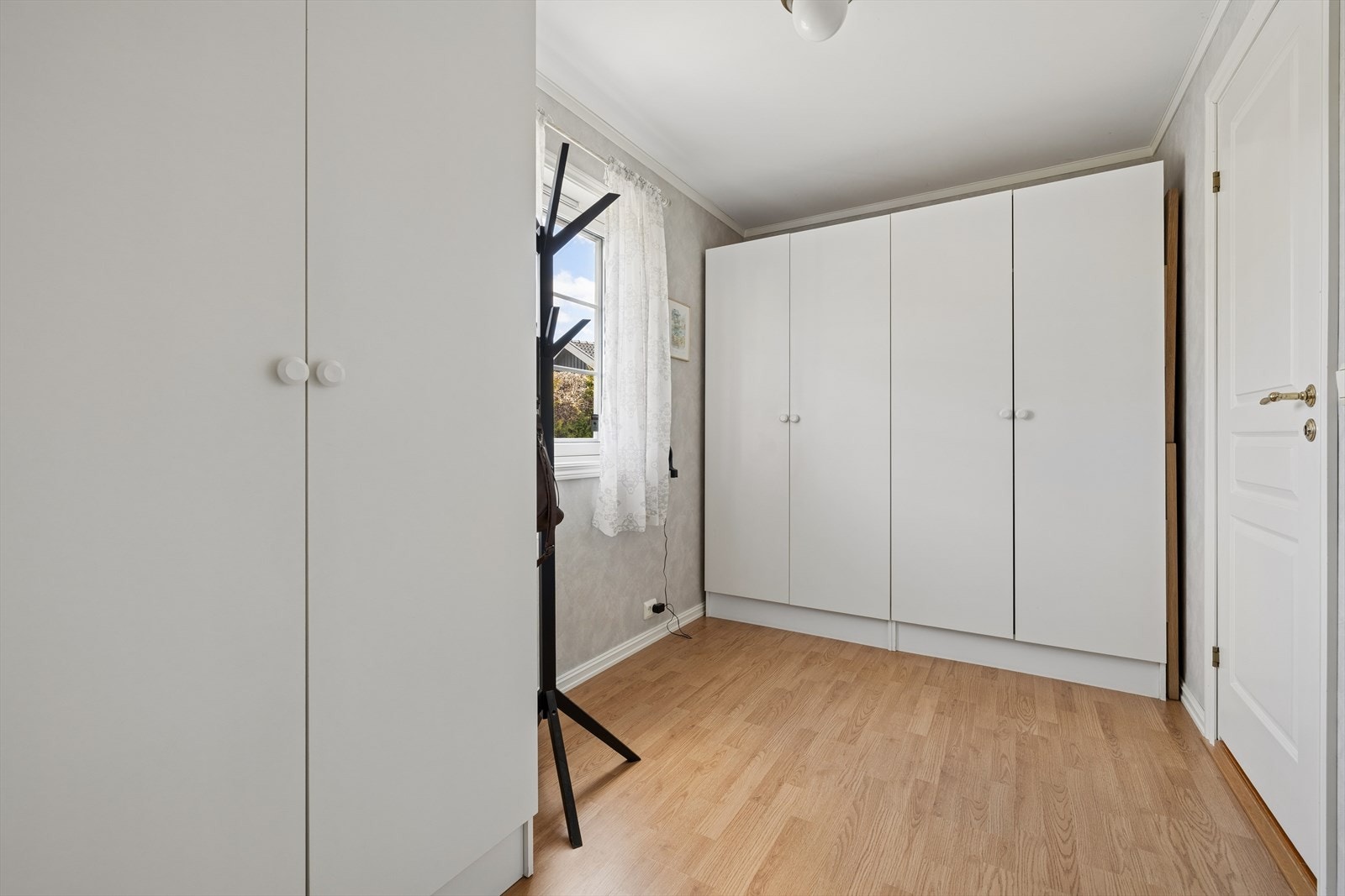 Praktisk rom ved entréen, i dag benyttet som garderobe og med videre adkomst til bod som brukes som vaskerom med opplegg for vaskemaskin og tørketrommel. Galleribilde