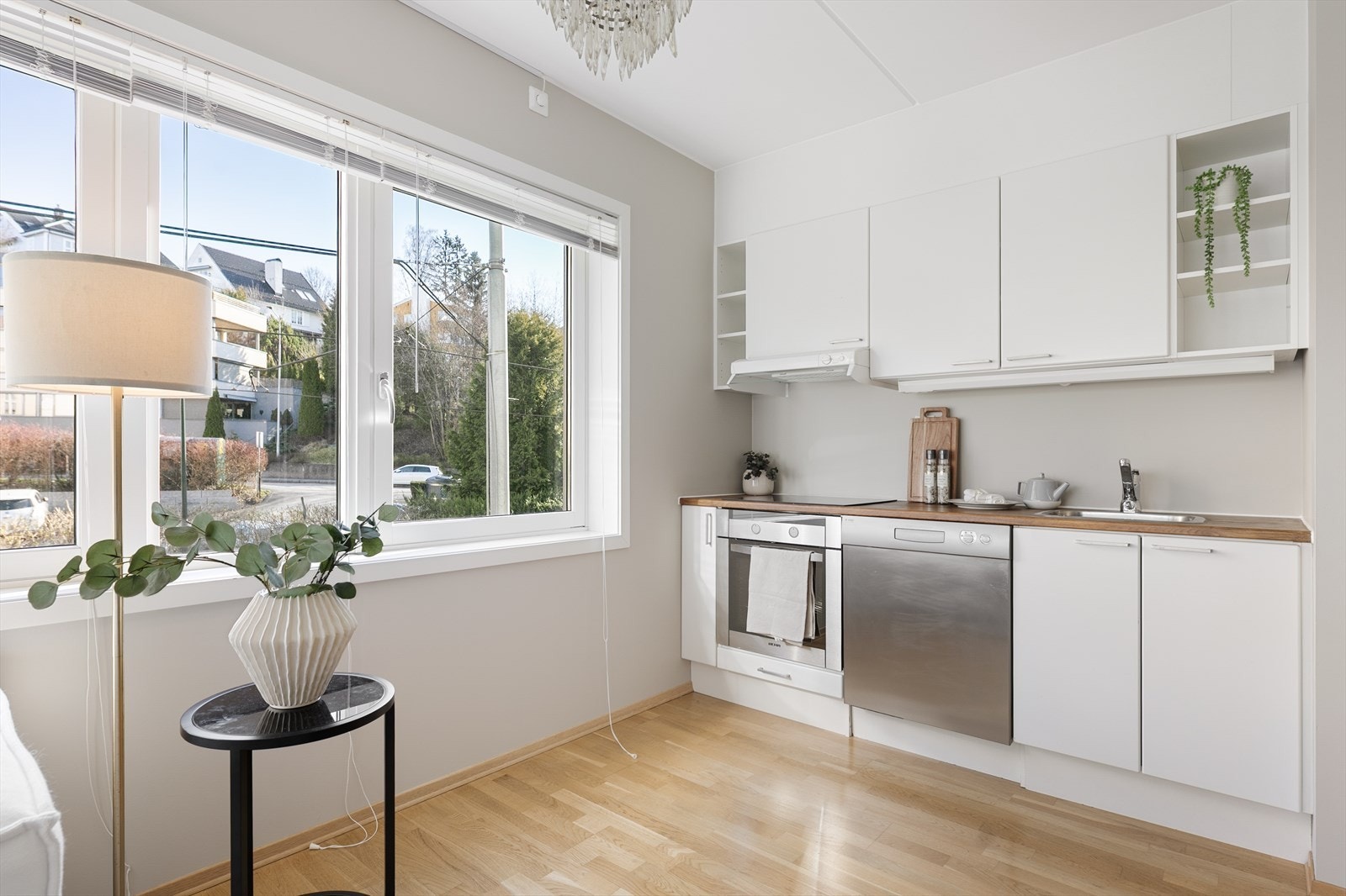 Kjøkkeninnredning med glatte fronter med benkeplate i tre med planlimt kum i rustfritt stål. Galleribilde