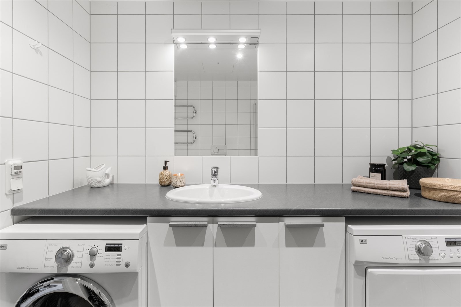 Baderomsinnredning bestående av benkeskap og hel benkeplate. Det er lagt varmekabler i gulv. Vaskemaskin og tørketrommel medfølger. Galleribilde