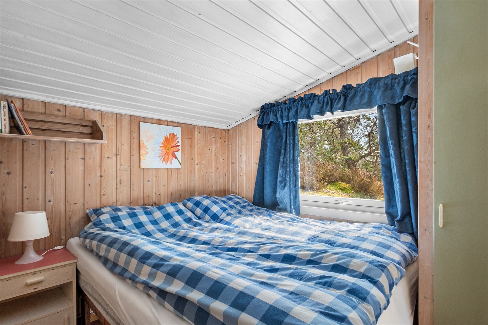 Det største soverommet har naturlig trepanel på vegger og hvitt tak, og har plass til dobbeltseng. Galleribilde