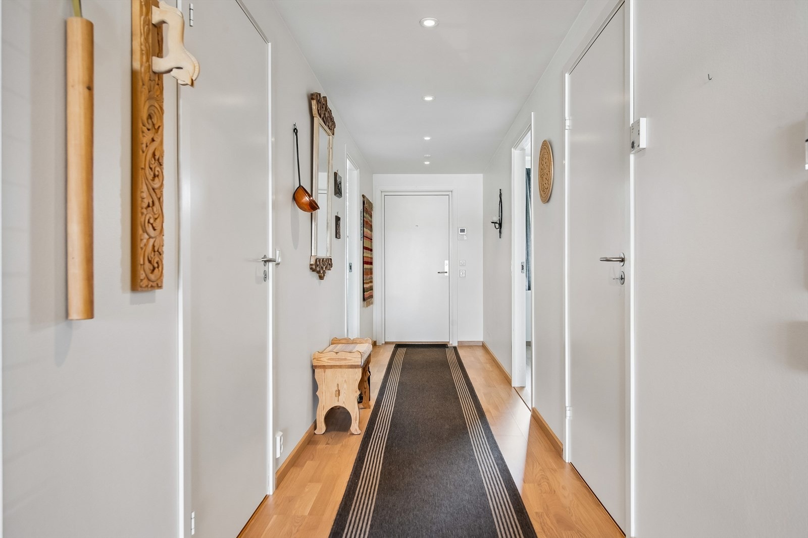 En romslig entré ønsker velkommen inn. Her er det parkett på gulv og malte, slette veggflater. Galleribilde