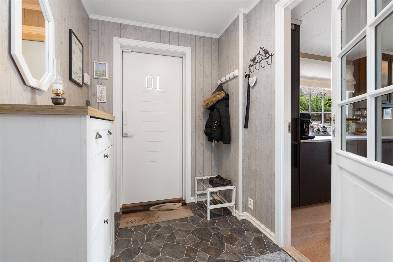 Lys og romslig entré i hovedetasjen, med belegg på gulv og god plass til oppbevaringsmøblement for sko- og yttertøy. Galleribilde