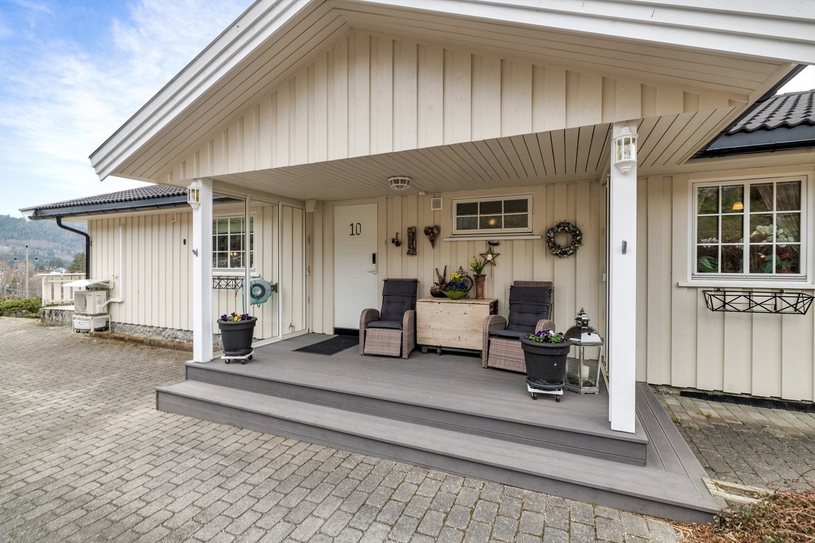 Hyggelig, overbygget inngangsparti mot øst. Inngangspartiet har utvendig platting med takoverbygg, og er oppbygget med impregnerte materialer i perioden 2018 til 2020. Galleribilde