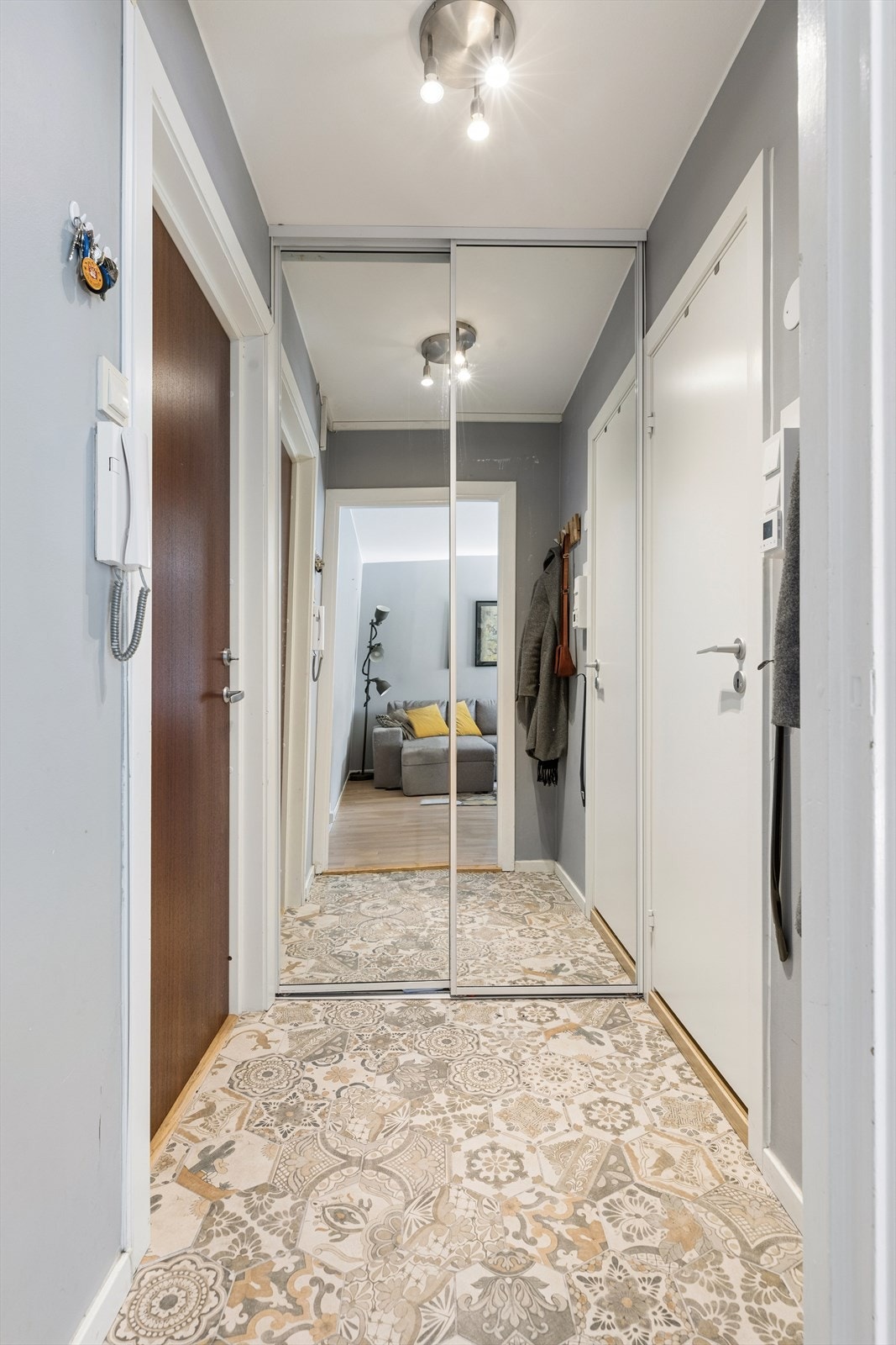 Til venstre for inngangsdøren er det en skyvedørsgarderobe med speilfronter som både gir praktisk oppbevaring og bidrar til å forstørre romfølelsen. Galleribilde