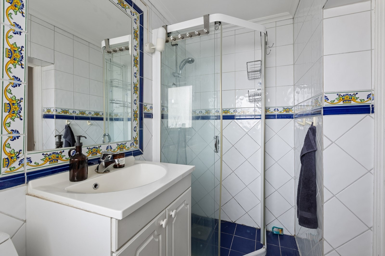 Badet er utstyrt med servant med underskap, toalett og et praktisk dusjhjørne. Galleribilde