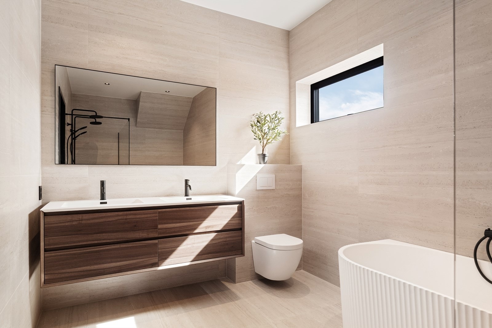 Badet er innredet med moderne baderomsinnredning, vegghengt toalett, flott badekar og en romslig dusjnisje med glassvegg Galleribilde