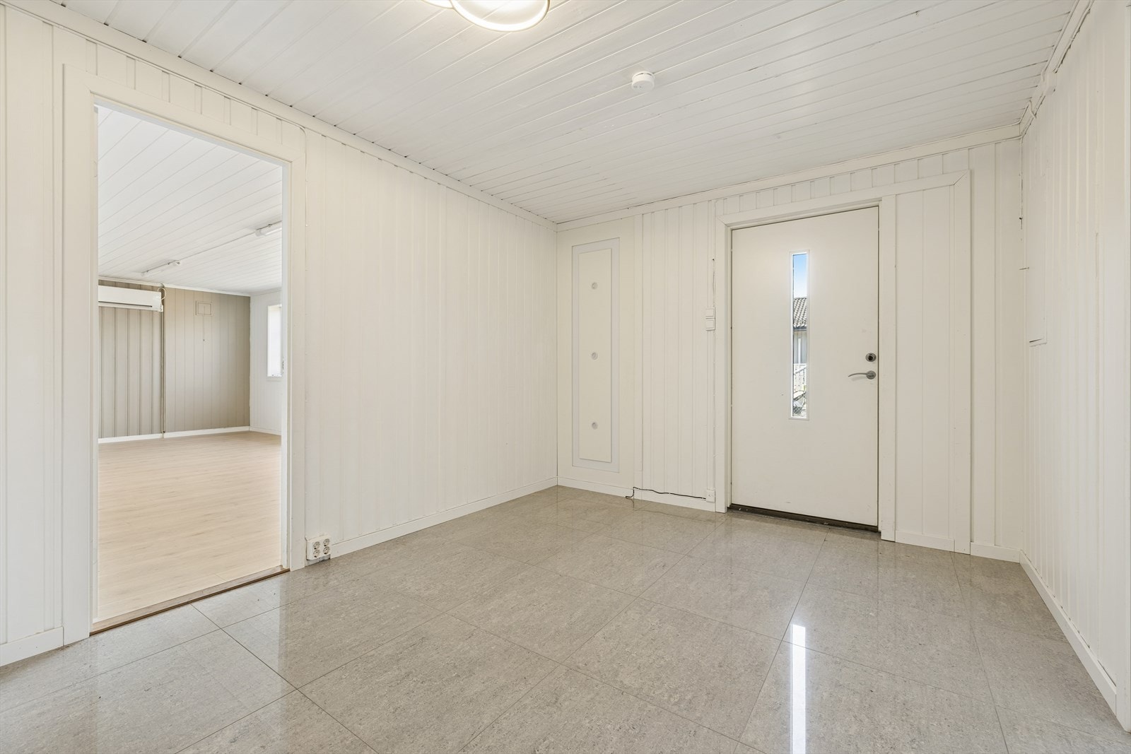 Stor flislagt entré med god plass til å sette fra seg sko og henge fra seg yttertøy. Galleribilde
