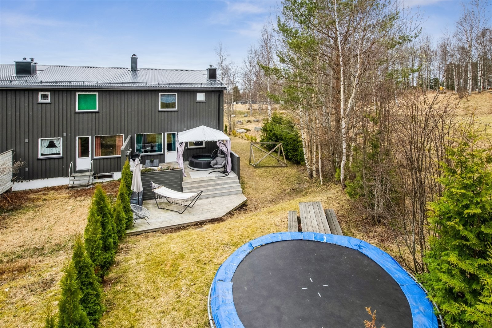 Enderekkehus med hage som strekker seg rundt boligen, og med en stor og flott terrasse over to nivåer. Galleribilde