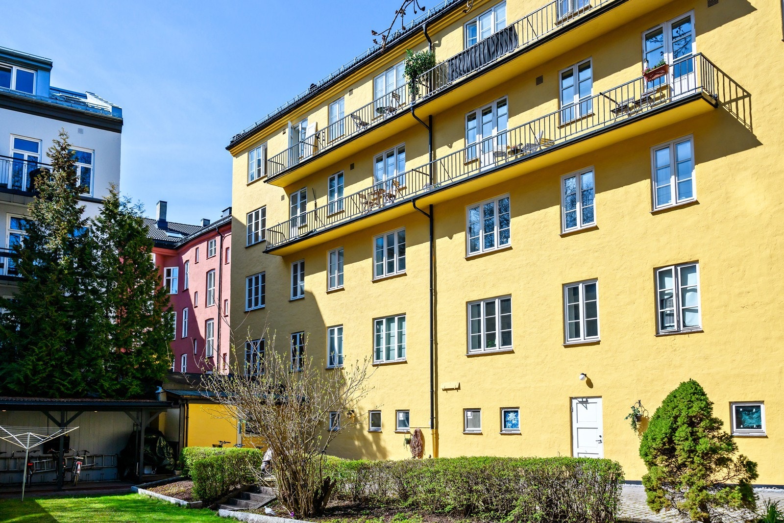Aksjelaget har en pent opparbeidet bakgård med grønn og frodig beplantning Galleribilde