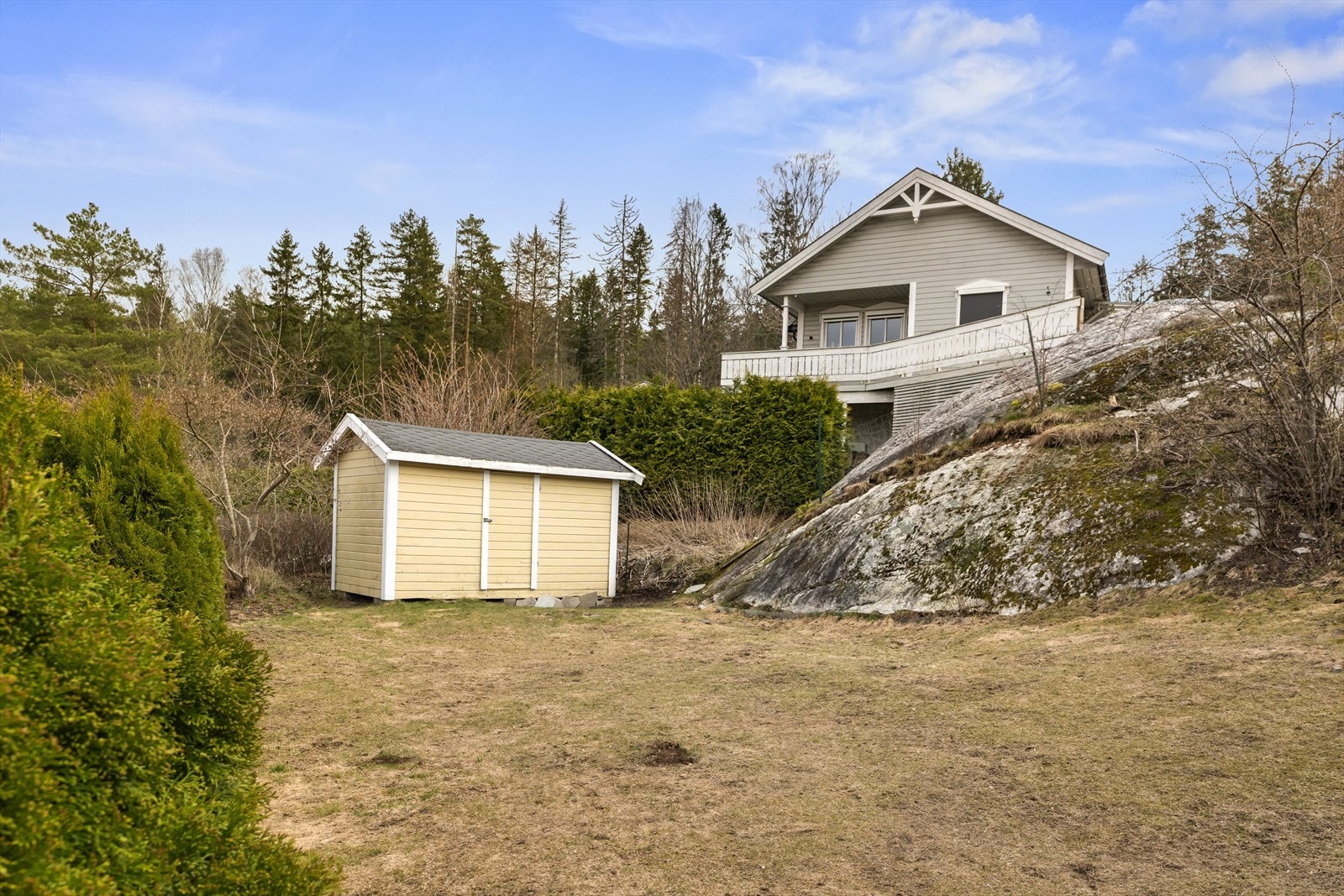 Hage med plen, naturtomt og frodig beplantning - praktrisk redskapsbod i enden av hagen. Galleribilde