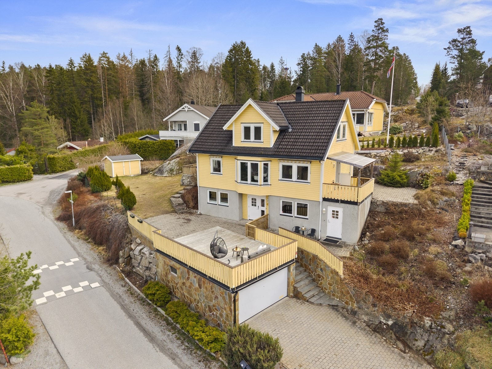 Boligen ligger plassert på skrånende tomt i et barnevennlig område, nær marka og grønne skogsområder. Galleribilde