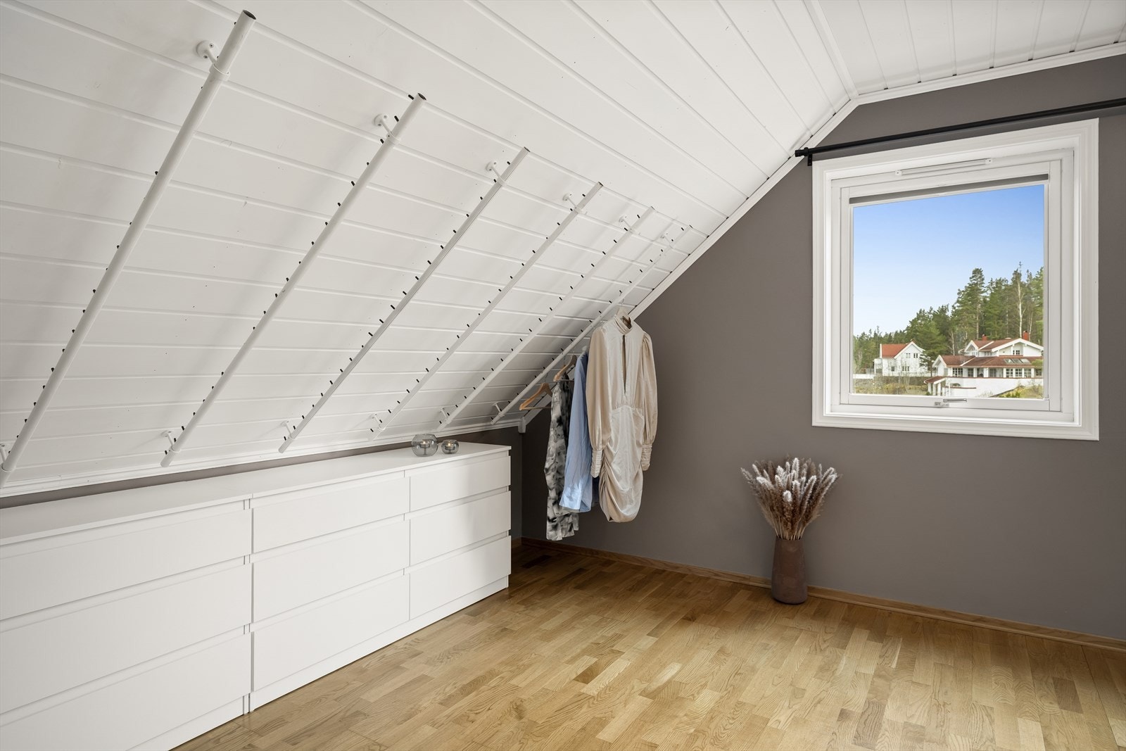 Garderobestenger montert langs taket i kneveggen. Galleribilde