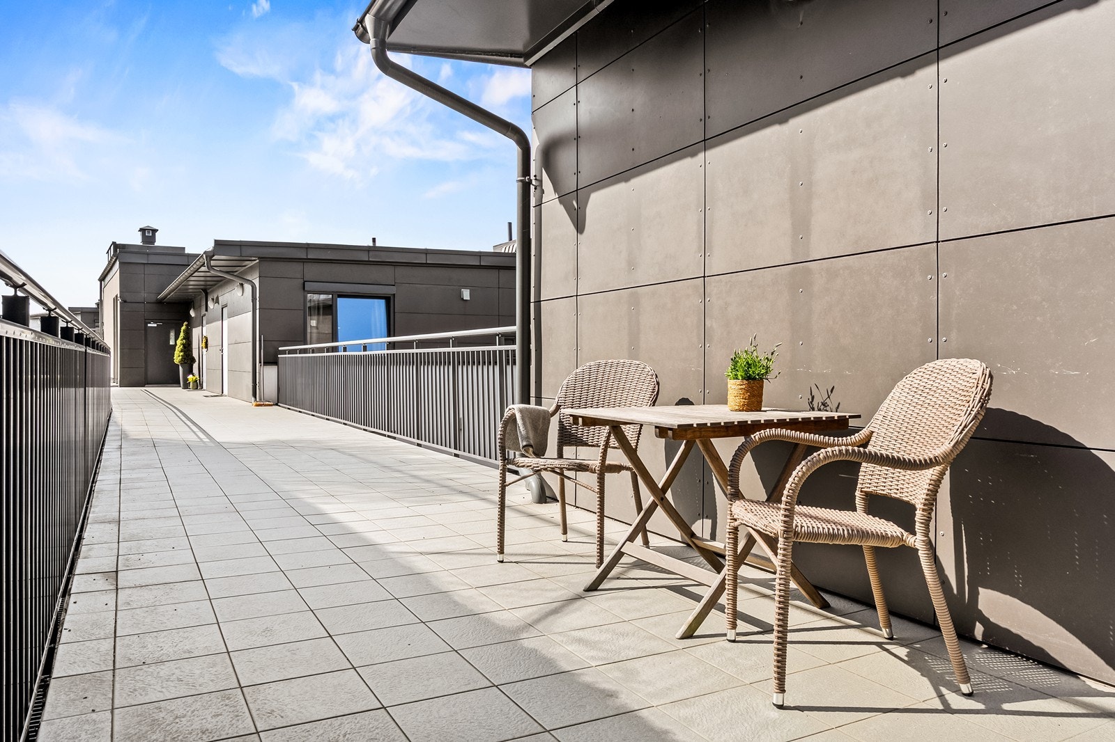 Uteplass ved svalgangen med plass for et lite kafésett. Galleribilde