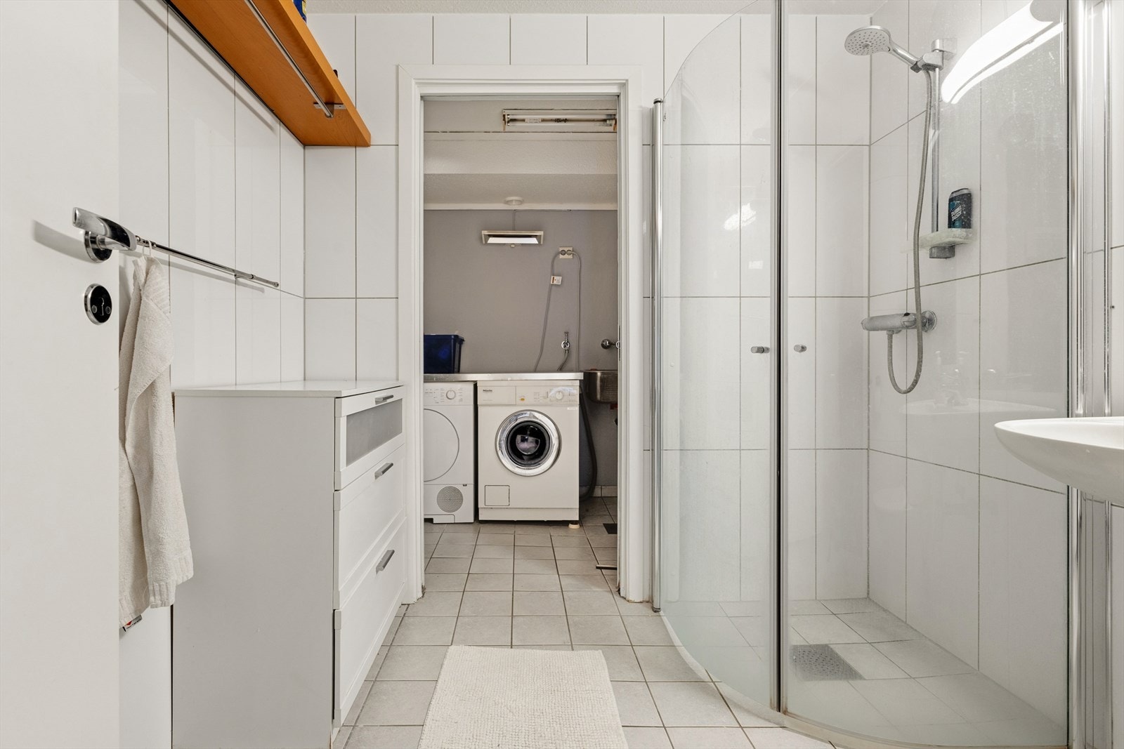 Fra badet er det direkte adkomst til et separat vaskerom med flislagt gulv, sluk og opplegg for vaskemaskin. Galleribilde