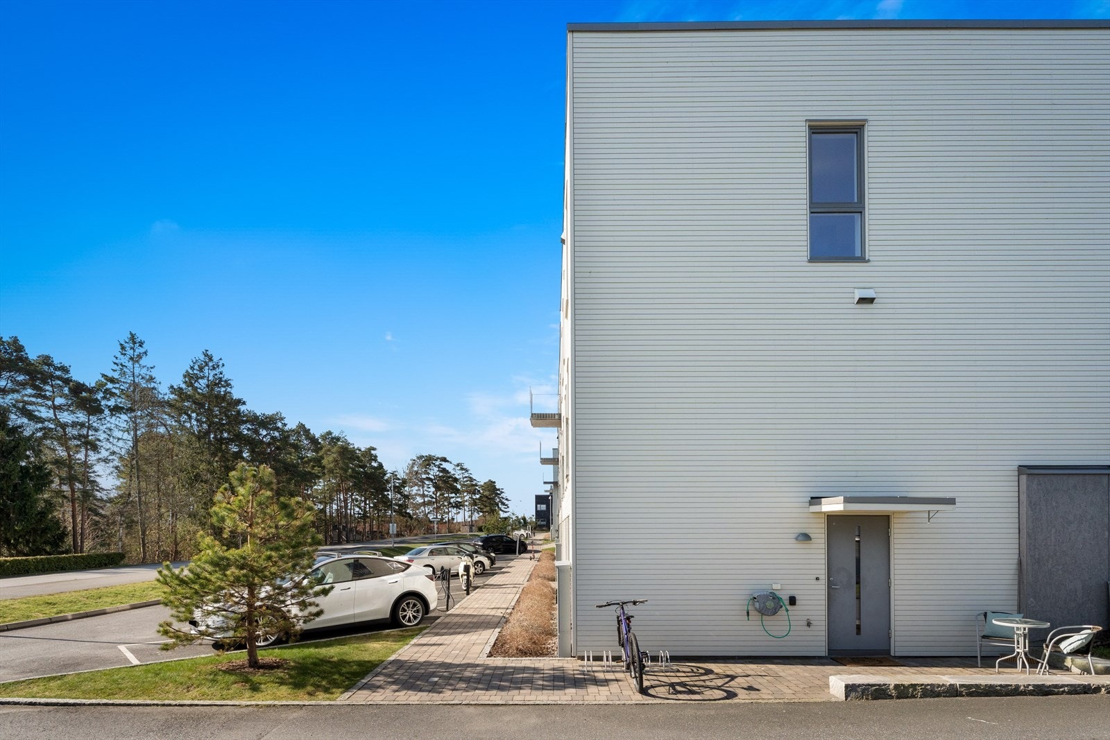 En malt inngangsdør med glassfelt ønsker deg velkommen inn i boligen. Galleribilde