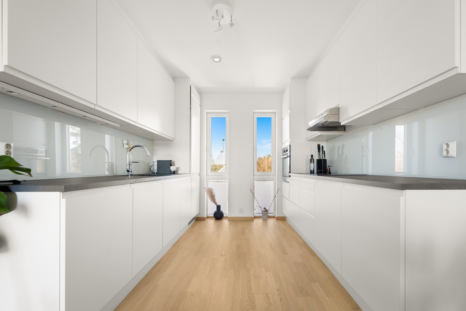 Med rikelig skap- og benkeplass på begge sider er dette et kjøkken som er godt rustet for matlaging og sosialt samvær. Galleribilde