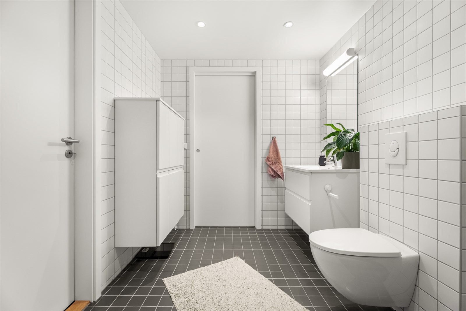 Rommet er utstyrt med en stilren servantinnredning og har god plass til ekstra oppbevaringsmøbler. Galleribilde