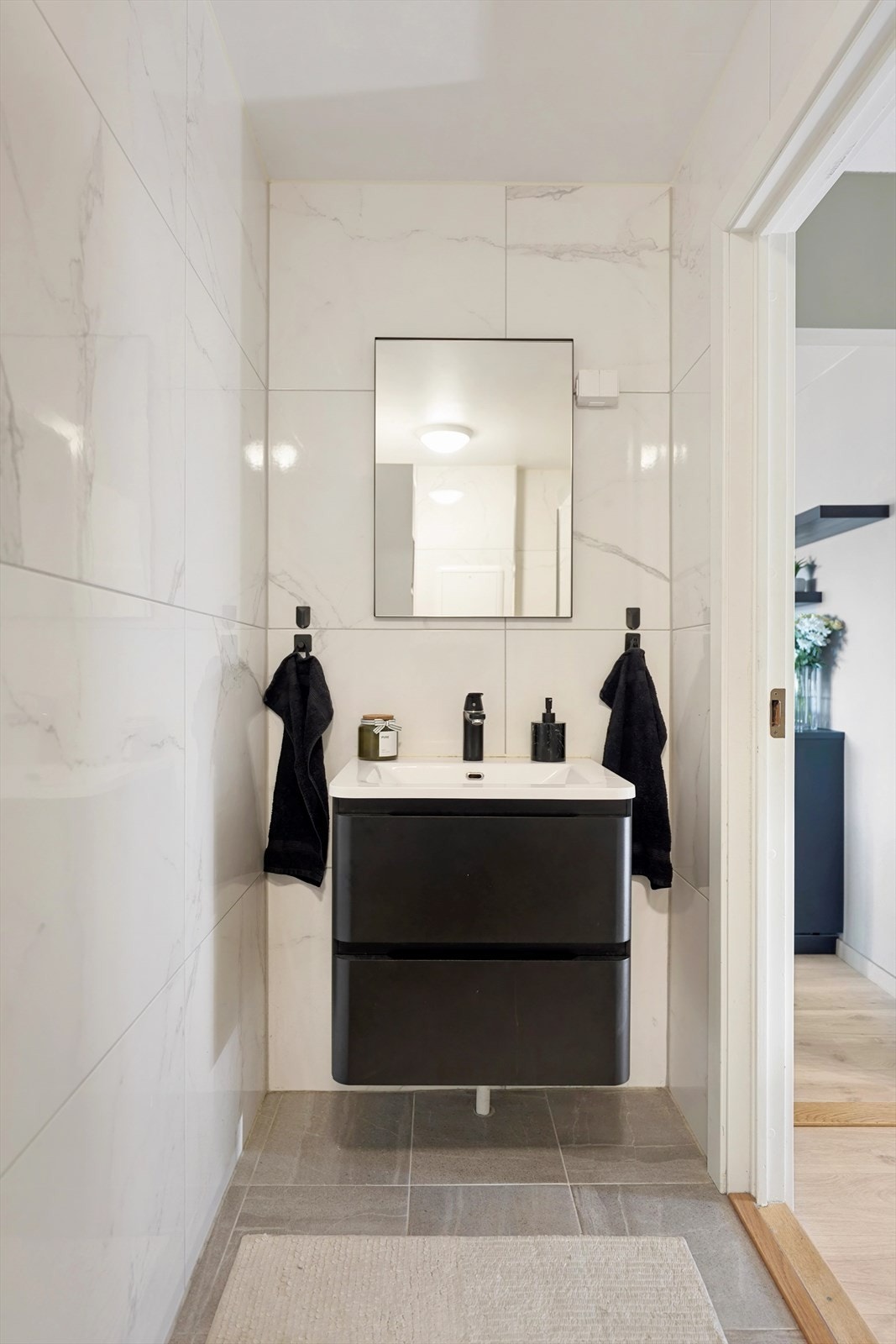 Badet har blant annet vegghengt toalett, dusjhjørne med svingdører og praktisk opplegg for vaskemaskin. Galleribilde
