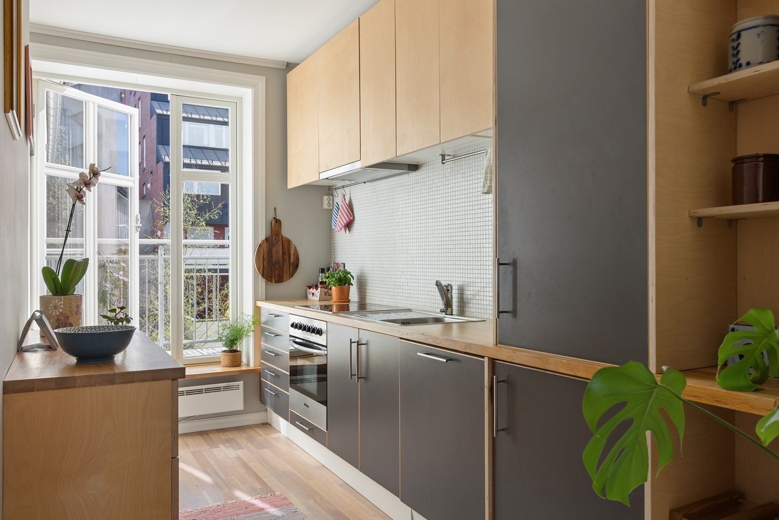 Praktisk IKEA-kjøkken med heltre benkeplate og medfølgende hvitevarer som stekeovn, platetopp og oppvaskmaskin. Galleribilde