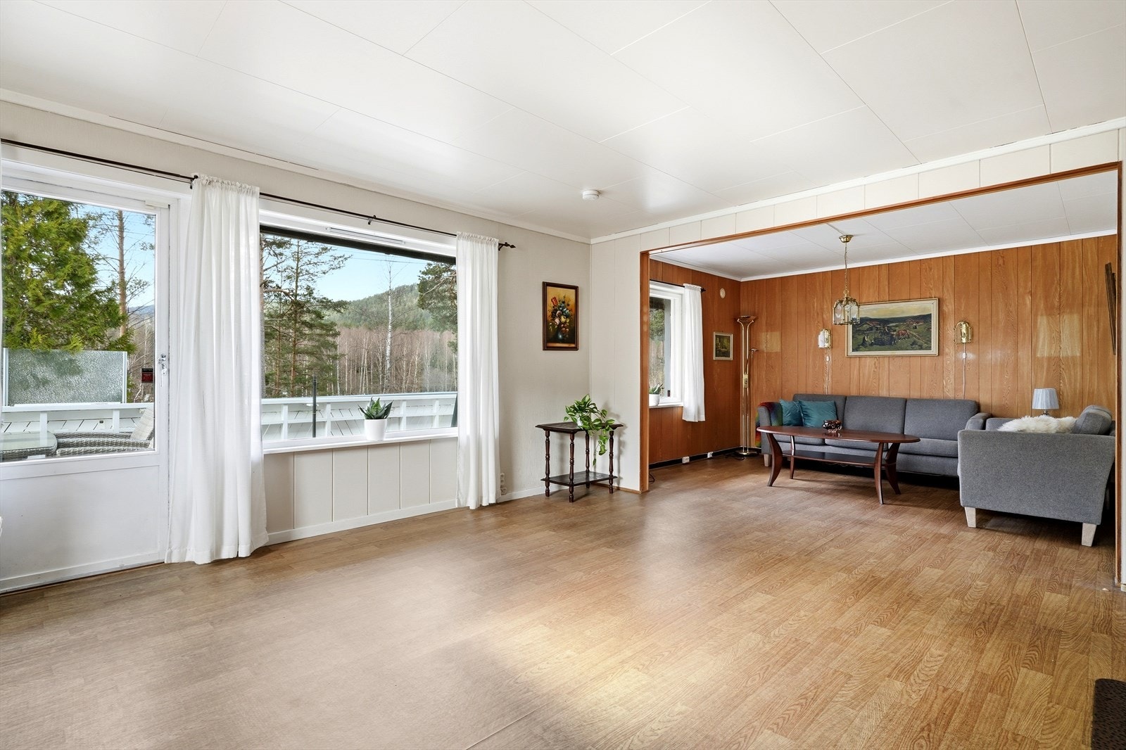 Stuen har laminat på gulv og store vindusflater som lysner opp rommet naturlig. Galleribilde