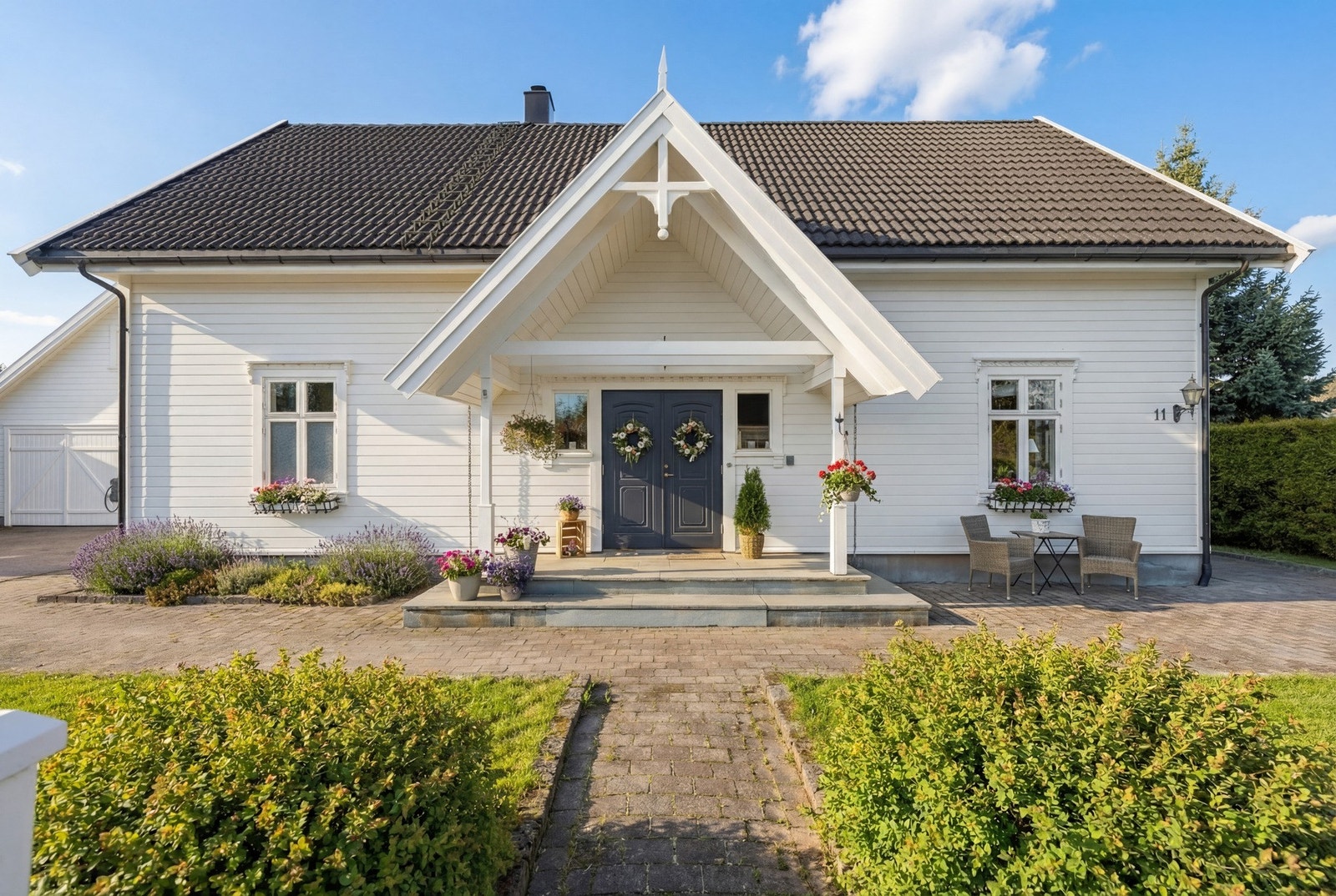 Et hyggelig inngangsparti belagt med skiferstein. (Fasadebilder er endret fra vinter til sommer ved bruk av AI. Avvik kan forekomme). Galleribilde