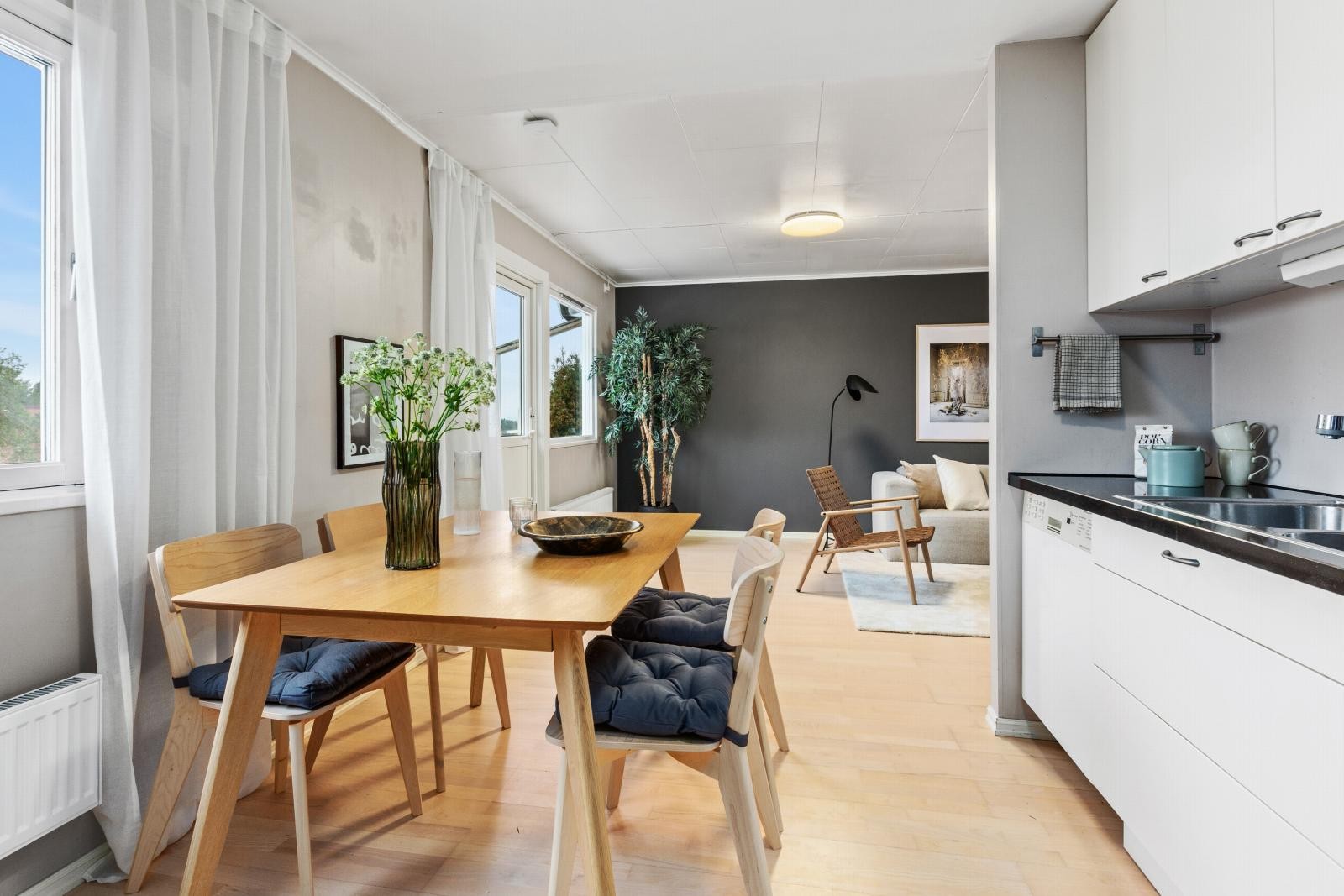 Lyst og moderne rom med åpen løsning mellom kjøkken og stue, store vinduer gir godt med naturlig lys. Galleribilde