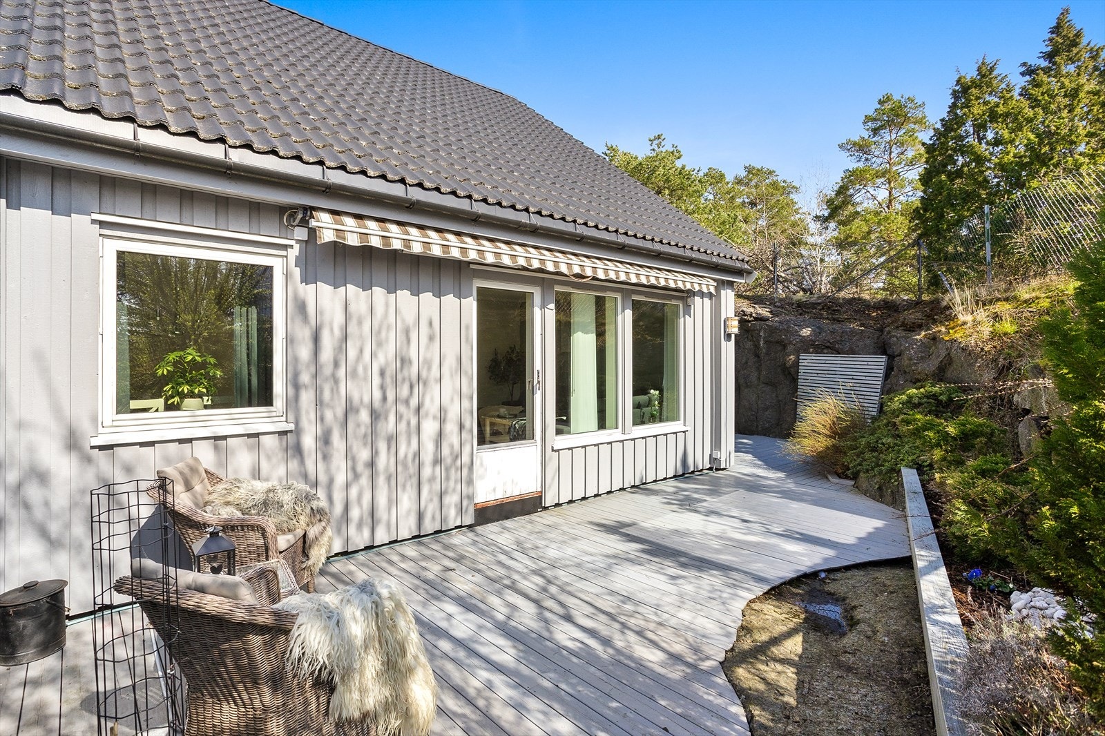 Fra stuen er det direkte utgang til en skjermet terrasse, som strekker seg rundt hele boligen. Galleribilde