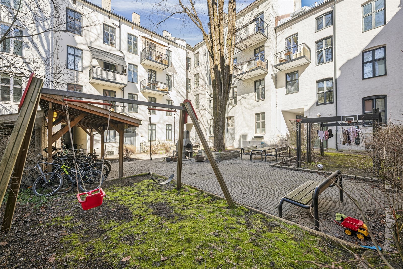 Bakgården har sittegrupper, lekestativ, sykkelskur og grill. Galleribilde