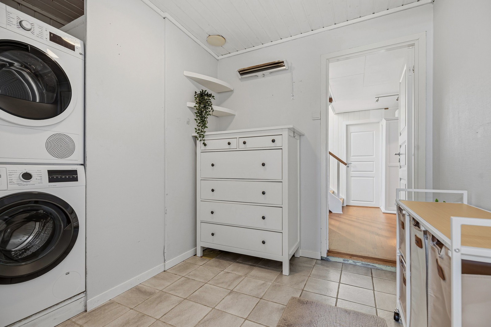 Separat vaskerom med flislagt gulv, opplegg for vaskemaskin og plass til oppbevaring. Galleribilde
